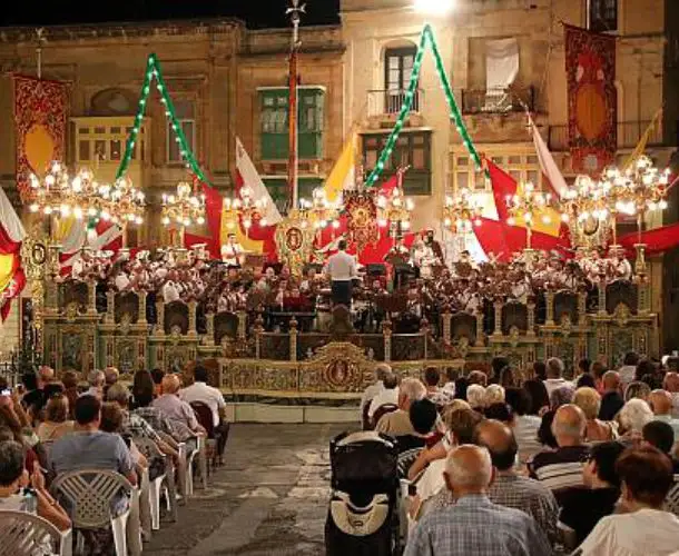Maltese village festa live band performance with audience, cultural music event, decorated square, and community gathering during summer festival in Malta
